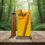 ซิการ์ Villiger Premium No.6 Honey Tip กล่องเหล็กสีเหลืองทอง วางคู่กับตัวมวนซิการ์ใบยาสูบธรรมชาติบนโต๊ะไม้
