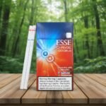 ซองบุหรี่ ESSE Change Double Applemango วางบนโต๊ะไม้ในบรรยากาศป่าเขียวขจี