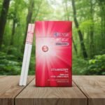 ซองบุหรี่ ESSE Change Strawberry สีชมพูสดใส วางคู่กับมวนบุหรี่บนโต๊ะไม้ในบรรยากาศป่าธรรมชาติ