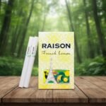 ซองบุหรี่ Raison French Lemon ลายหอไอเฟลสีเหลืองสดใส พร้อมมวนบุหรี่วางบนโต๊ะไม้