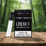ซองบุหรี่ Lincoln Special One สีดำพรีเมียมและมวนบุหรี่วางบนโต๊ะไม้ในสวนป่า