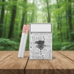 ซองบุหรี่ Texas 5 Silver และมวนบุหรี่ วางบนโต๊ะไม้ในบรรยากาศป่าธรรมชาติ