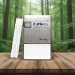 ซองบุหรี่ Dunhill Gray 3mg สีเงินเมทัลลิคสไตล์เรียบหรู วางบนโต๊ะไม้ในบรรยากาศป่าธรรมชาติ
