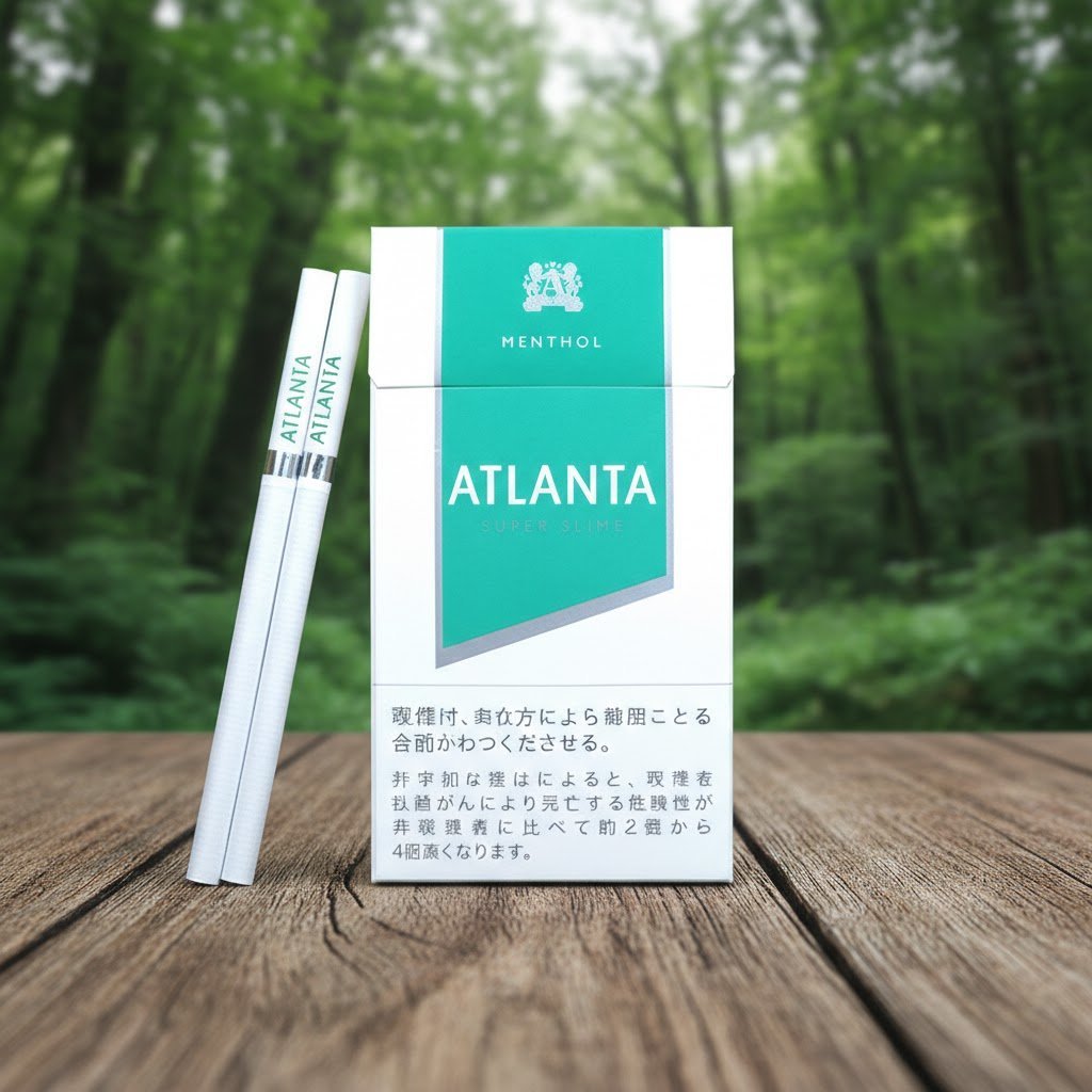 ซองบุหรี่ Atlanta Green Super Slims วางบนโต๊ะไม้ในบรรยากาศสวนป่า ดีไซน์ซองสีขาวแถบเขียวเมนทอล