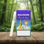 ซองบุหรี่ Raison French Line Blue ลายหอไอเฟลและพลุสีสวยงาม วางบนโต๊ะไม้ฉากหลังป่าสีเขียว