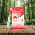 ซองบุหรี่ Oris Strawberry สีแดงขาวลายผลสตรอว์เบอร์รี วางบนโต๊ะไม้ฉากหลังเป็นป่าธรรมชาติ