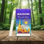 บุหรี่ Raison French Line Blue ซองสีน้ำเงินม่วงลายหอไอเฟลและพลุ วางคู่กับมวนบุหรี่สลิมบนโต๊ะไม้ฉากหลังป่า
