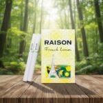 บุหรี่ Raison French Lemon ซองสีเหลืองลายกราฟิกหอไอเฟล พร้อมมวนบุหรี่สีขาววางบนโต๊ะไม้ฉากหลังป่า