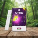บุหรี่ Oris Twin Sense Berry Mix ซองสีม่วงพรีเมียม พร้อมมวนบุหรี่แบบ 2 เม็ดบีบ วางบนโต๊ะไม้ฉากหลังป่า