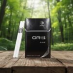ซองบุหรี่ Oris Nano Black สีดำดีไซน์เรียบหรู วางคู่กับมวนนาโนสลิมบนพื้นโต๊ะไม้ ท่ามกลางบรรยากาศป่าไม้เขียวชอุ่ม