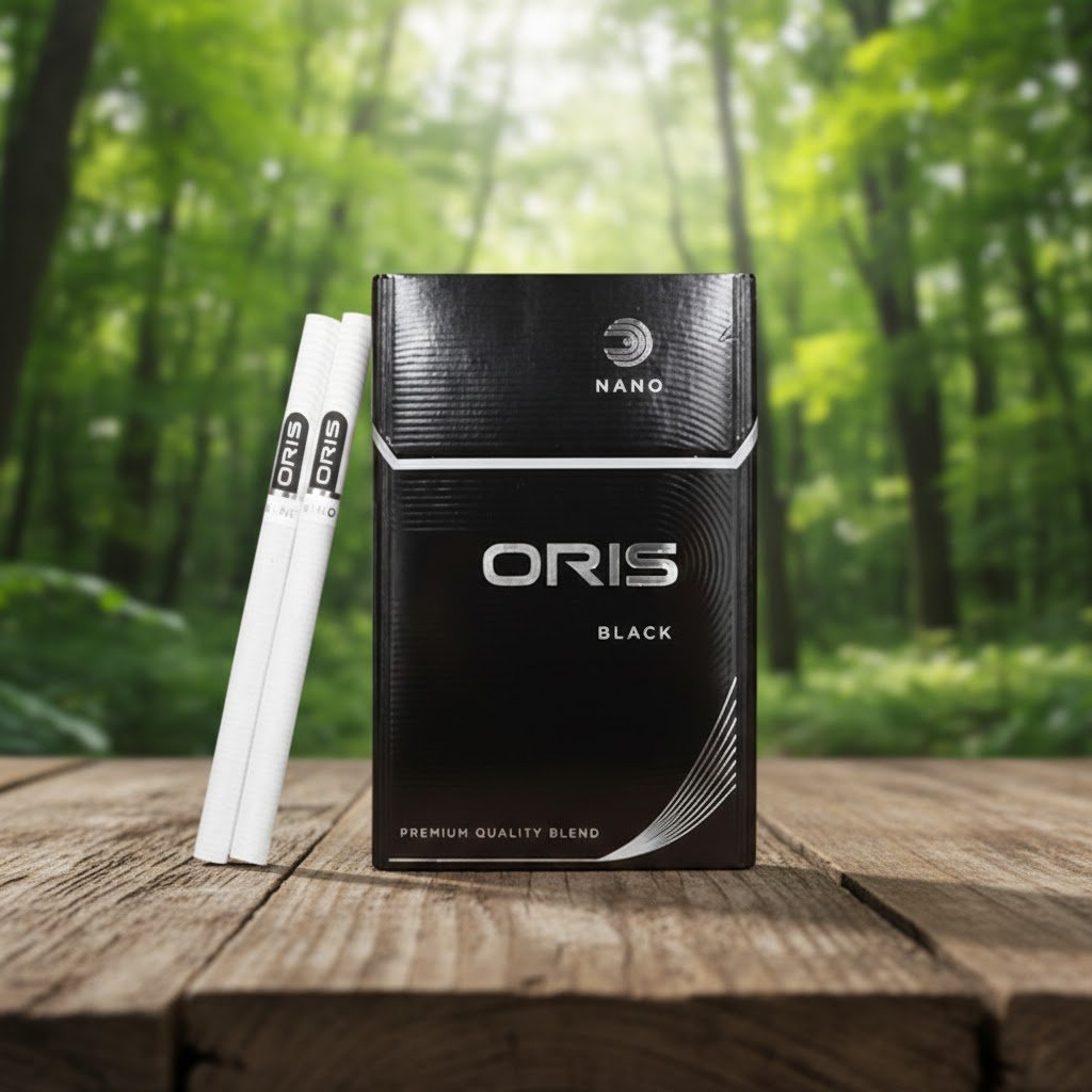 ซองบุหรี่ Oris Nano Black สีดำดีไซน์เรียบหรู วางคู่กับมวนนาโนสลิมบนพื้นโต๊ะไม้ ท่ามกลางบรรยากาศป่าไม้เขียวชอุ่ม