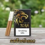 บุหรี่ Tora Cigarillos รสช็อกโกแลต ซองสีดำลายเสือทอง วางบนโต๊ะไม้ในสวน