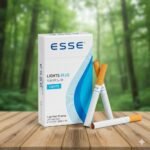 บุหรี่ ESSE Lights Blue ซองสีขาวลายกราฟิกสีฟ้า มวนซูเปอร์สลิมวางบนโต๊ะไม้ฉากหลังป่าสีเขียว