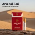 ซองบุหรี่ Arsenal Red สีแดงเข้มวางบนขอนไม้ท่ามกลางทะเลทราย ดีไซน์พรีเมียม รสร้อนเข้มข้น