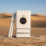 ซองบุหรี่ 555 State Express Mandarin Deluxe สีขาวหรูหรา วางบนขอนไม้กลางทะเลทราย แสงแดดอุ่น พร้อมมวนบุหรี่ก้นกรองแบบหลุม