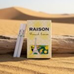 ซองบุหรี่ Raison French Lemon วางบนขอนไม้กลางทะเลทราย ดีไซน์ซองสีเหลืองลายหอไอเฟล