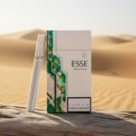ซองบุหรี่ ESSE Menthol Slim สีขาวคาดเขียวโฮโลแกรม วางบนขอนไม้ในทะเลทราย แสงแดดสีทองพรีเมียม