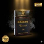 ซองบุหรี่ Bokormas Universal Fine สีดำหรูหราตัดขอบแดงและทอง วางเด่นท่ามกลางควันและประกายแสงสีทอง พร้อมป้าย Luxury Kretek และ Premium Blend