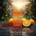 ซองบุหรี่ Oris Pulse Orange สีส้มสดใส วางคู่กับผลส้มผ่าซีกและใบยาคุณภาพ ท่ามกลางบรรยากาศสวนส้มยามเย็น