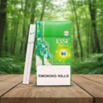 ซองบุหรี่ ESSE Menthol Plus+ สีเขียวสดใสพร้อมมวนบุหรี่แบบสลิมวางบนโต๊ะไม้ในป่าธรรมชาติ