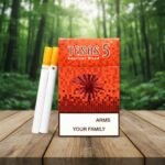 บุหรี่ Texas 5 Red Hard เท็กซัสสีแดงแบบซองแข็ง วางบนโต๊ะไม้ฉากหลังพื้นหลังป่า